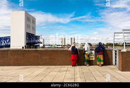 Donne che indossano shalwar kameez e dupatta, in piedi nella parte anteriore del Woolwich Ferry Terminal in Londra, Regno Unito Foto Stock