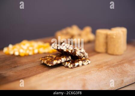 Tipici piatti brasiliani del Partito di giugno (Festa Junina) su un tavolo di legno: Arachidi caramelle (paçoca e pe-de-moleque), nocciole di mais, cialde di arachidi. Spazio di copia. Foto Stock