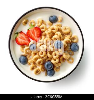 ciotola di anelli per la colazione con latte e bacche isolati su sfondo bianco, vista dall'alto Foto Stock