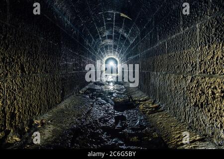 Scuro e creepy vecchio storico a volta allagato tunnel sotterraneo di drenaggio Foto Stock