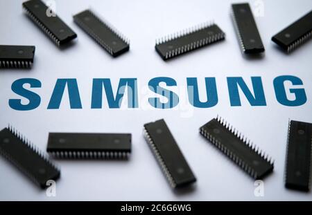 Stone / Regno Unito - 9 luglio 2020: Logo Samsung sul documento stampato e grandi microchip collocati intorno. Messa a fuoco selettiva. Foto Stock