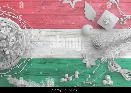 Bandiera ungherese su tavola di legno con oggetti neve. Natale e Capodanno, celebrazione nazionale concetto con decorazioni bianche. Foto Stock
