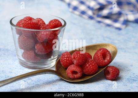 Lamponi in cucchiaio e recipiente in vetro, Germania Foto Stock