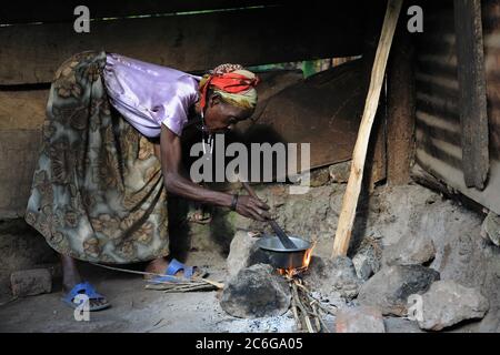 Donna che prepara il caffè sul fuoco, Uganda Foto Stock
