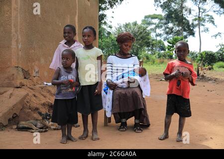 Famiglia, donna, bambini, bambino, seduto di fronte al capanno di fango, Uganda, Africa orientale Foto Stock