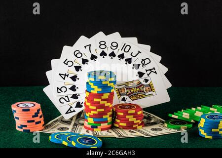 Elementi di gioco del casinò come chip colorati, carte da poker e denaro Foto Stock