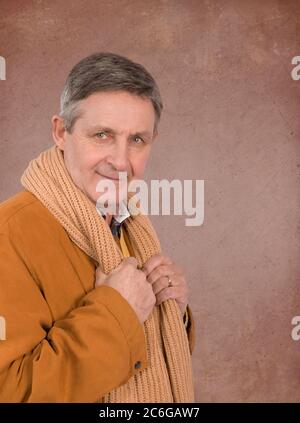 Attraente uomo anziano elegantemente vestito con giacca e sciarpa maglione Foto Stock