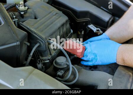 Mani di meccanico auto che lavora batteria di ricambio in auto riparazione servizio. Foto Stock