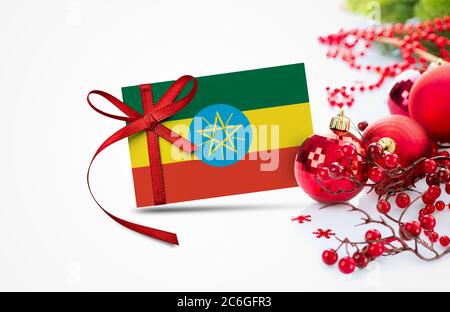 Bandiera Etiopia su carta di invito anno nuovo con ornamenti rossi di natale concetto. Nazionale felice anno nuovo composizione. Foto Stock