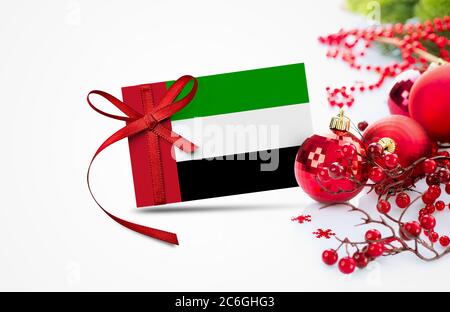 Bandiera degli Emirati Arabi Uniti su carta di invito per il nuovo anno con il concetto rosso di ornamenti natalizi. Nazionale felice anno nuovo composizione. Foto Stock