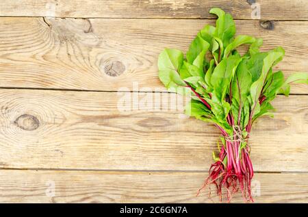 Germogli di barbabietole giovani su sfondo di legno. Foto Foto Stock