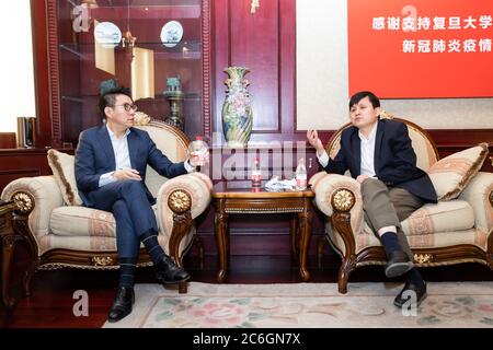 A nome della China Football Association, segretario principale della CFA Liu Yi, a sinistra, parla con il professor Zhang Wenhong dell'ospedale di Huashan, a destra, Shangha Foto Stock