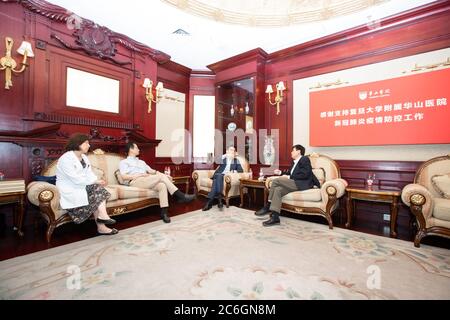 A nome della China Football Association, segretario principale della CFA Liu Yi, di centro destra, parla con il professor Zhang Wenhong, di destra, il professor Wang Huiyin Foto Stock