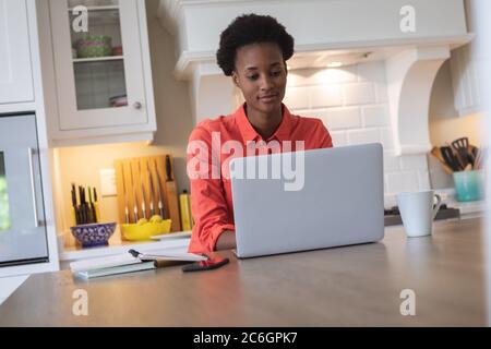 Donna con notebook in cucina Foto Stock