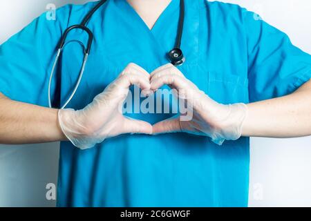 Medico maschile in camice blu mostra come segno isolato su bianco - immagine ritagliata. Foto Stock