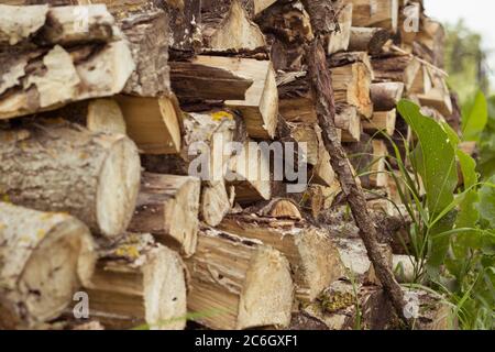 Legna di fuoco impilata fuori del cottage nel giorno estivo del villaggio Foto Stock