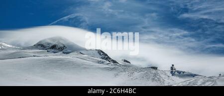 Bianche montagne invernali coperte di neve in cielo azzurro nuvoloso. Alpi. Austria. Pitztaler Gletscher Foto Stock