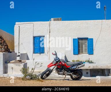 Grecia. Oia città sull'isola di Santorini. Moto rosso di fronte alla casa Foto Stock