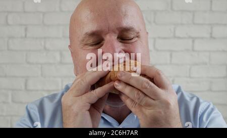 Una persona affamata che mangia un hamburger gustoso, gusta un delizioso spuntino in un ristorante fast food Foto Stock