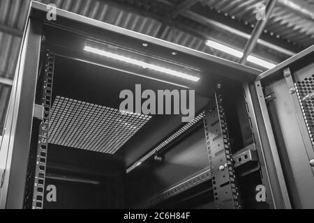 Immagine dettagliata di un computer e di un cabinet del server di rete che mostra lo sportello anteriore aperto. Una striscia luminosa a LED è visibile sul tetto interno. Foto Stock