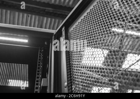 Immagine dettagliata di un computer e di un cabinet del server di rete che mostra lo sportello anteriore aperto. Una striscia luminosa a LED è visibile sul tetto interno. Foto Stock