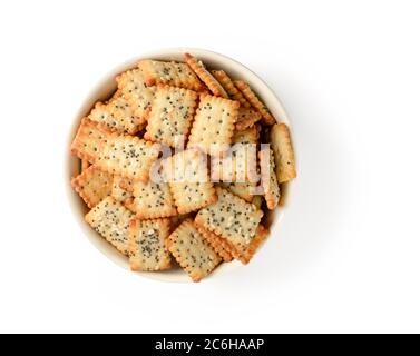 Piccoli cracker rettangolari salati con semi di papavero e sesamo in una ciotola di ceramica beige isolata su sfondo bianco. Spuntino croccante di farina di grano. Foto Stock