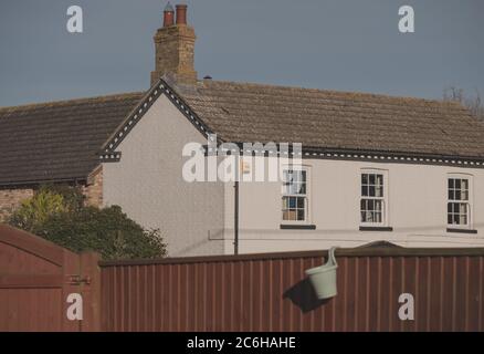 Vista dettagliata di una scatola di allarme senza fili installata di recente, fissata al lato di un vecchio cottage in mattoni. Foto Stock