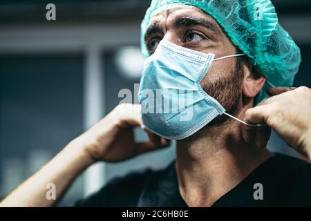 Chirurgo preparazione per l'operazione chirurgica - operatori medici i veri eroi durante l'epidemia di virus corona Foto Stock