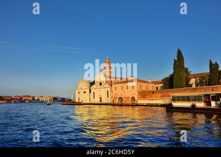 Vista dalla laguna di Venezia sulla chiesa di San Michele in Isola e sul famoso cimitero isola di San Michele al tramonto, Murano isola sul backgro Foto Stock