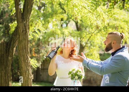 Appena sposato coppia hipster amorevole in abito da sposa e vestito nel parco. Felici sposi e sposi che camminano e ballano. Romantico sposato giovane fa Foto Stock