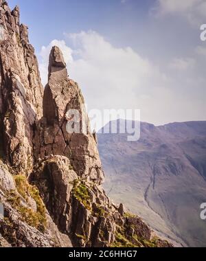 L'immagine mostra gli scalatori in azione scalando la formazione rocciosa di Napes Needle sul lato della montagna di Great Gable alla testa della valle di Wasdale nel Distretto Inglese del Lago essendo un obiettivo popolare come diritto di passaggio con gli scalatori di roccia di ogni generazione Foto Stock