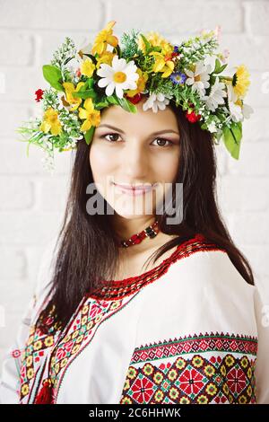 Ritratto di una bella ragazza in abito nazionale ucraino e una corona di fiori Foto Stock