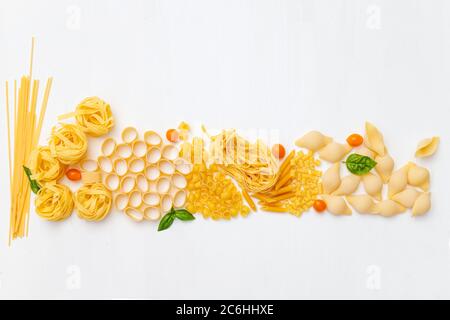 Pasta varia cruda su sfondo bianco di legno. Vista dall'alto. Pasta italiana per ristorante con spazio per testo. Foto Stock