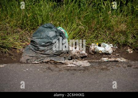 LARKHALL, Scozia, Regno Unito. 10 luglio 2020. Nella foto: Rifiuti scartati illegalmente sul lato di una strada tranquilla. Il fly-tipping costa ai consigli britannici milioni di euro all'anno per smaltire correttamente. Durante il blocco del coronavirus (COVID19), i centri di smaltimento dei rifiuti gestiti dal consiglio hanno chiuso lasciando le persone a rifornire i loro rifiuti che non potevano già essere deposti nelle collezioni di bidoni. Altre persone hanno fatto ricorso a discariche nella parte del paese. Credit: Colin Fisher/Alamy Live News Foto Stock