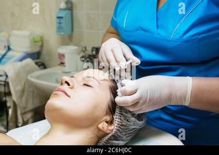 Estetista esegue un trattamento di mesoterapia con ago sul viso di una donna Foto Stock