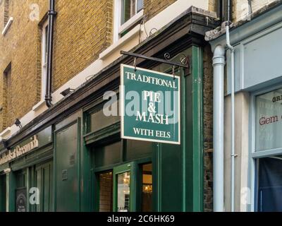 Greenwich, Londra, Regno Unito; segno per un negozio che vende torta e schiacciare con anguille, un cibo tradizionale di classe operaia dall'East End di Londra. Foto Stock