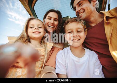 Prendendo un selfie dal punto di vista del cellulare. Buona famiglia che guarda la fotocamera scattando una foto durante la vacanza. Foto Stock