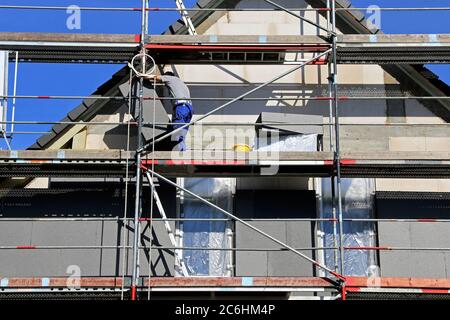 I lavoratori edili isolano la facciata della casa Foto Stock