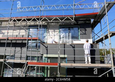 I lavoratori edili isolano la facciata della casa Foto Stock