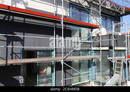 I lavoratori edili isolano la facciata della casa Foto Stock