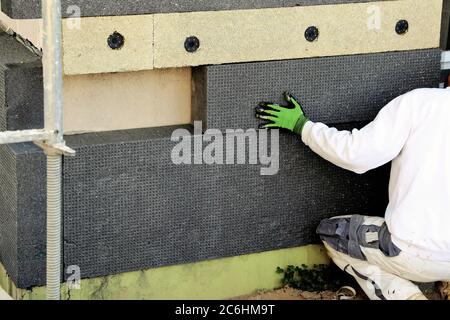 I lavoratori edili isolano la facciata della casa Foto Stock