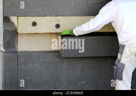 I lavoratori edili isolano la facciata della casa Foto Stock