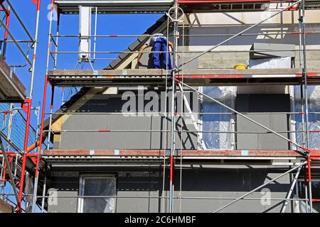 I lavoratori edili isolano la facciata della casa Foto Stock