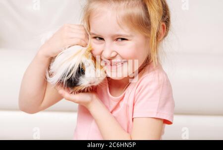 Carino girk poco avendo un sacco di divertimento con porcellino d'India peruviana Foto Stock