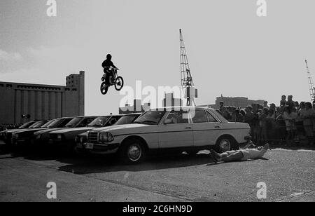 Il pilota stunt Eddie Kidd salta diverse vetture nei docklands di Londra intorno al 1987 Foto Stock