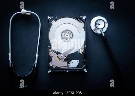Riparazione del disco rigido utilizzato per l'archiviazione su personal computer su sfondo scuro Foto Stock