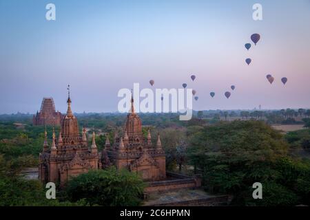 Mongolfiere si innalzano sopra i templi e pagode all'alba a Old Bagan, Myanmar Foto Stock