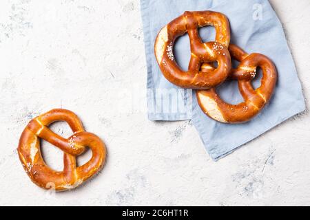 Pretzel freschi sul retro su un asciugamano blu, spuntino di birra, vista dall'alto con spazio per le copie Foto Stock