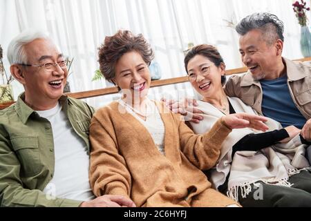 Due coppie felici si siedono e chiacchierano Foto Stock
