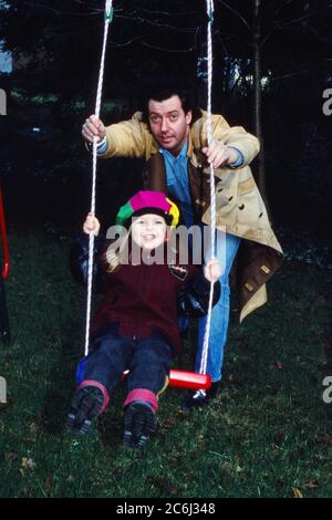 Kay Sabban, deutscher Schauspieler, spielt mit seiner Tochter im Garten in Amburgo, Deutschland 1990. Foto Stock